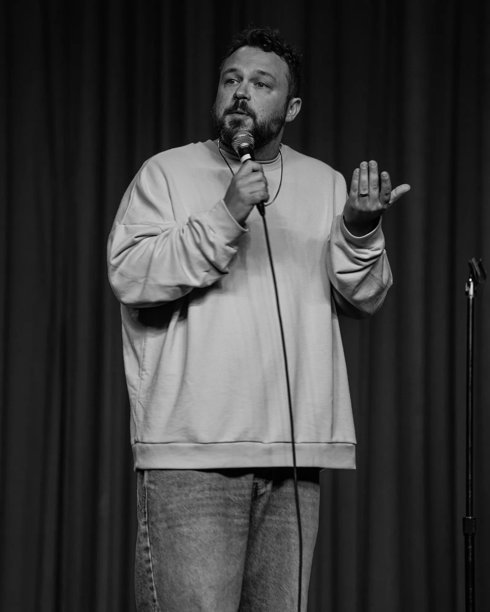 Ben Bankas performing stand-up with a microphone in Charles Town, West Virginia