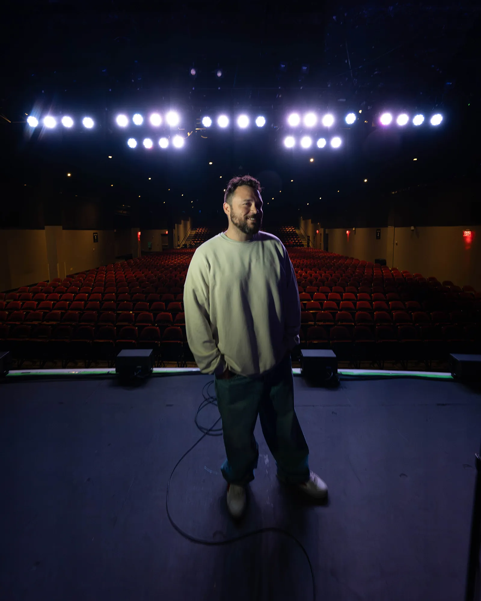 Ben Bankas performing stand-up on a theater stage in Charles Town, West Virginia